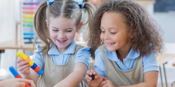 Two girls playing with loose parts as part of a STEM activity